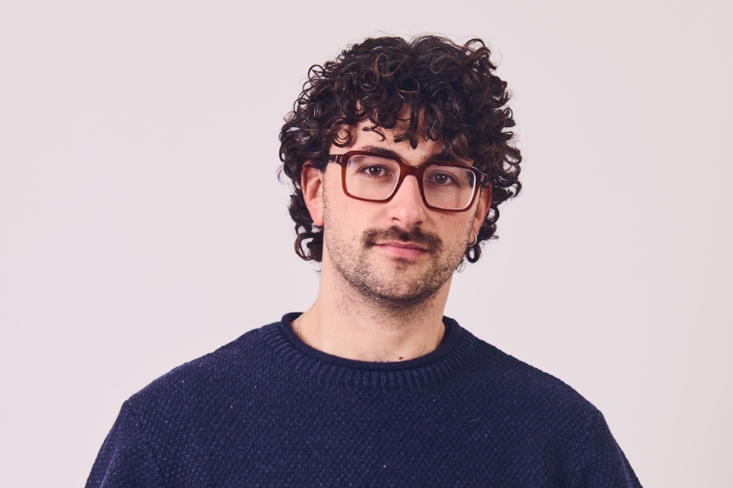 Man with glasses, black curly hair and a moustache